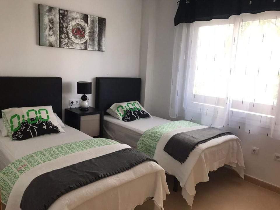 1 Schlafzimmer mit 2 Betten und einem Fenster in der Unterkunft Las terrazas de la torre golf Heidi in Murcia