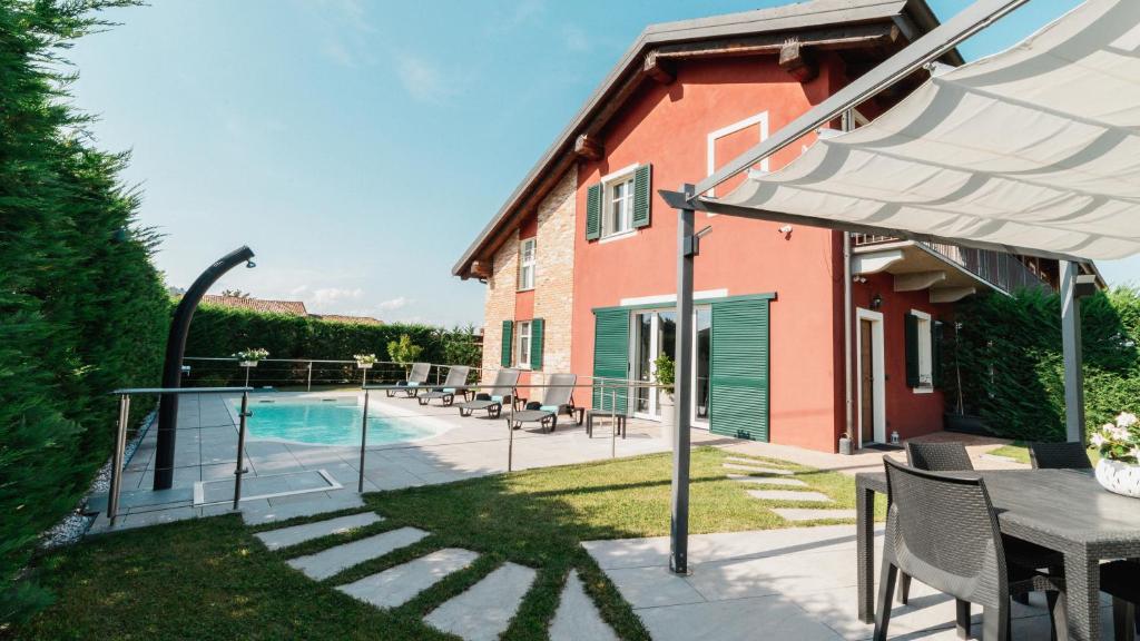 a house with a swimming pool and a patio at Casa Vecchio Mulino in Alba