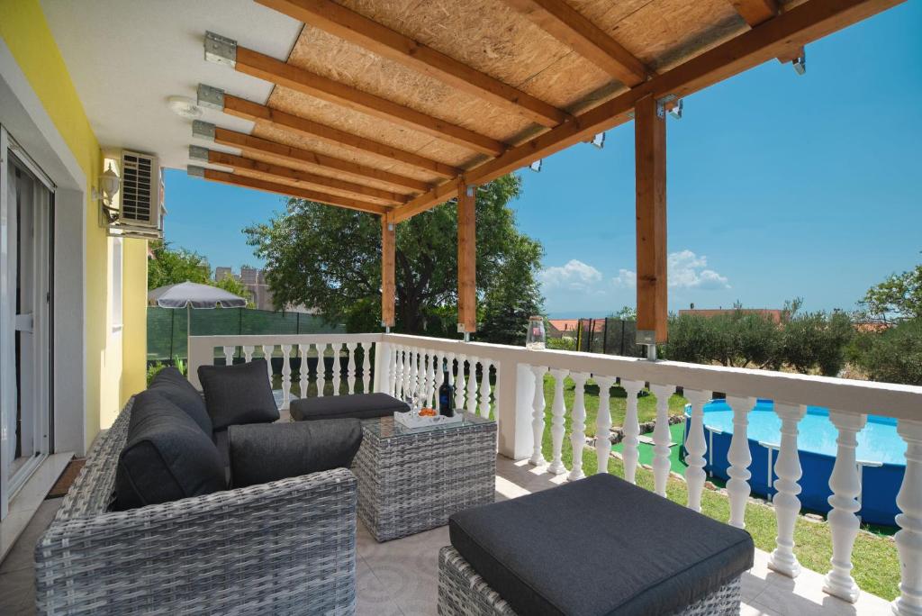 a patio with couches and chairs on a balcony at Holiday home Paligan in Solin