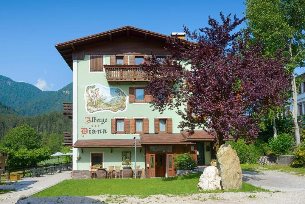 a building with a sign that reads happy bite at Hotel Diana in Auronzo di Cadore