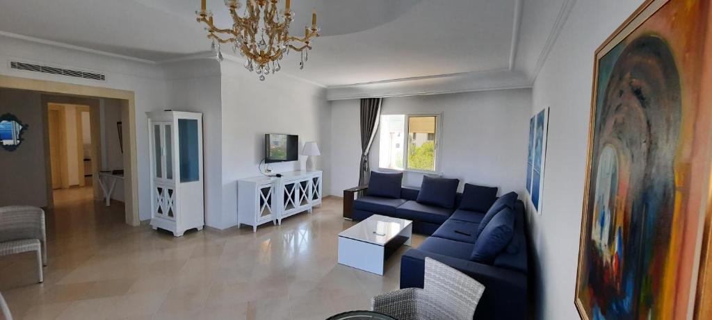 a living room with a blue couch and a table at Le Bleu Céleste in Hammamet