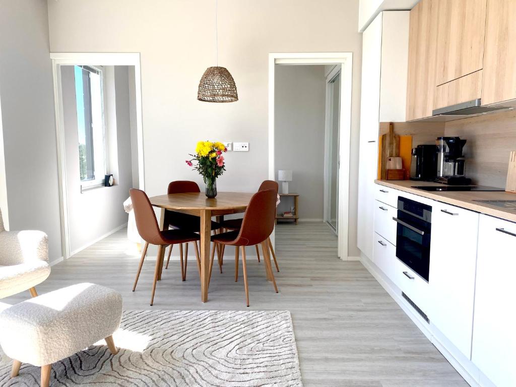 uma cozinha com uma mesa e cadeiras numa cozinha em Apartment Adventure & Sea - Top Floor em Kalajoki