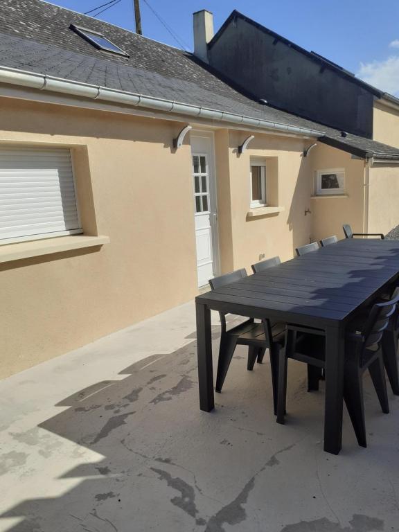 a black picnic table in front of a house at Le Rêve de Marcel in Le Molay-Littry
