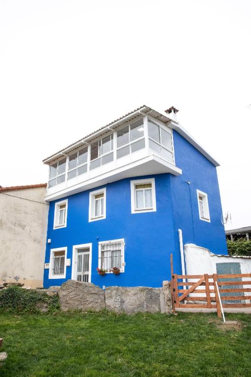a blue house with a white balcony at Casa Lires Recarey in Grijoa