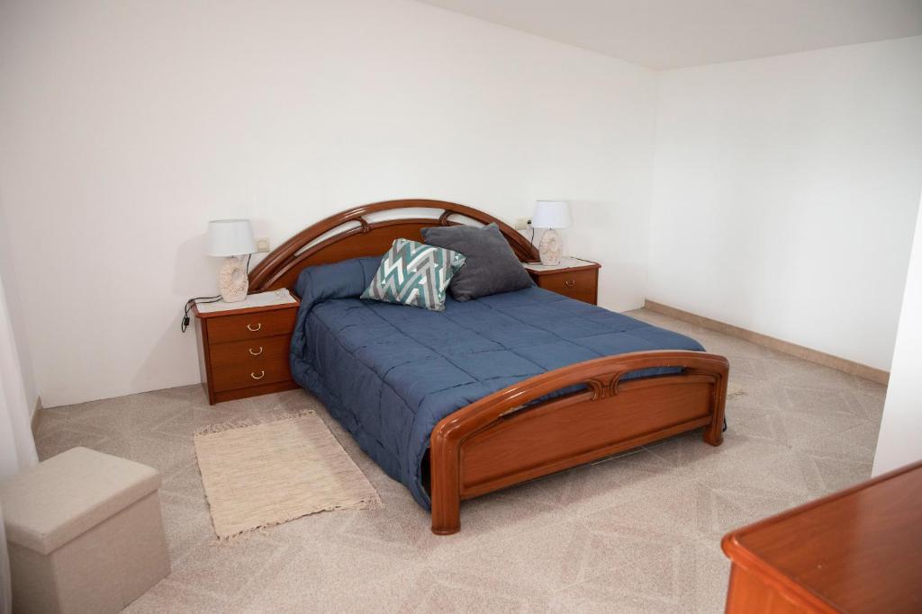 1 dormitorio con 1 cama con manta azul y 2 mesitas de noche en Casa Lires Recarey, en A Coruña