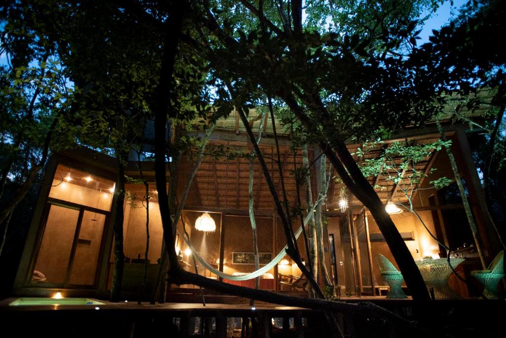 a house lit up at night with lights at OJO DE ÁRBOL, boutique cabin in the real jungle in Tulum