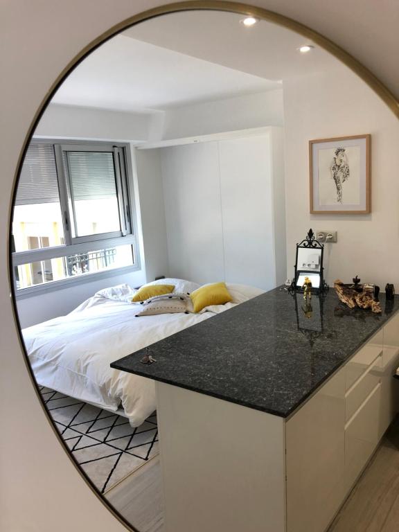 a mirror reflecting a bedroom with a bed at Cocoon Paris La Defense in Courbevoie