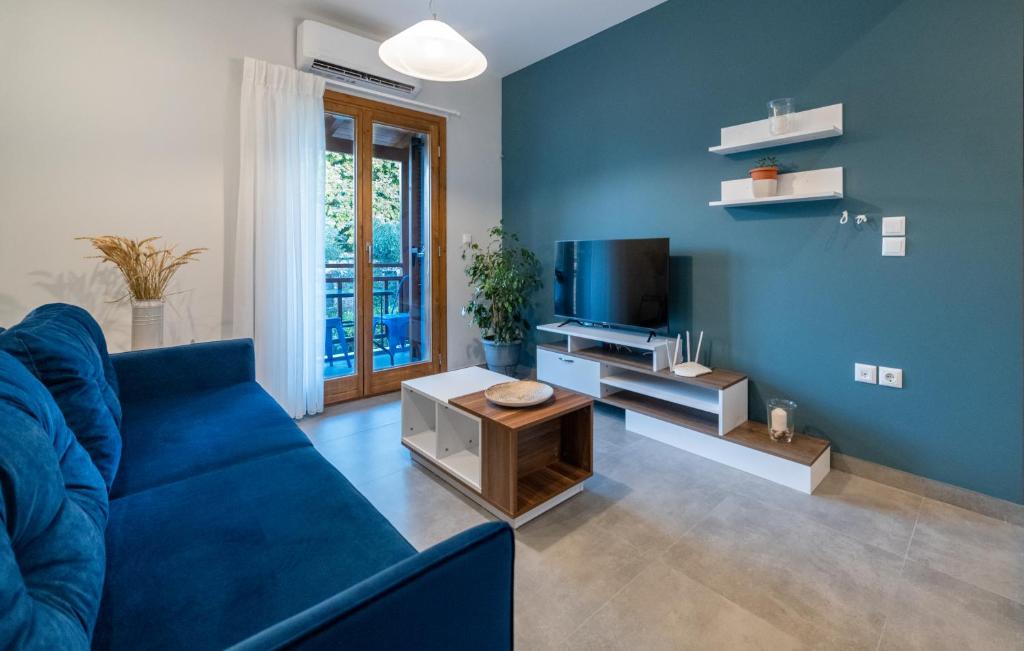 a blue living room with a blue couch and a tv at IONIS Apartments in Preveza