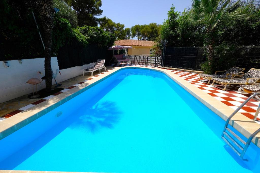 a large swimming pool with blue water in a yard at Villa Porta Caeli in Tarragona