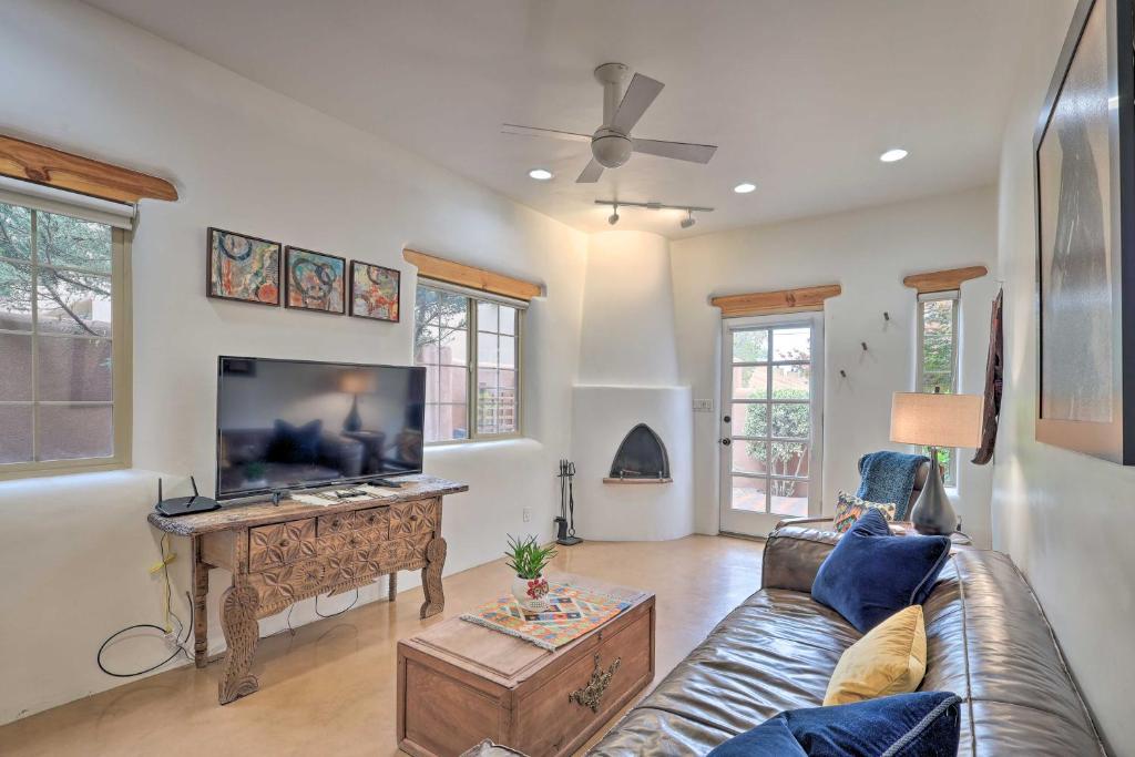 ein Wohnzimmer mit einem Sofa und einem Flachbild-TV in der Unterkunft Historic Railyard Bungalow - Walkable Location! in Santa Fe