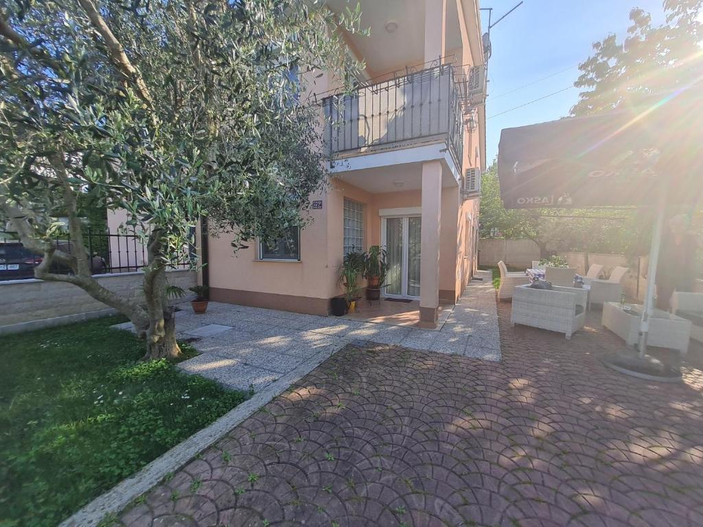 a house with a tree and a patio at Stanovanje v mirni zeleni okolici in Koper