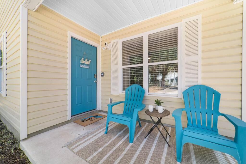 Dos sillas azules en un porche con una puerta azul en NEW Modern Bungalow Close to Downtown! Fully Fenced Yard, en St. Augustine