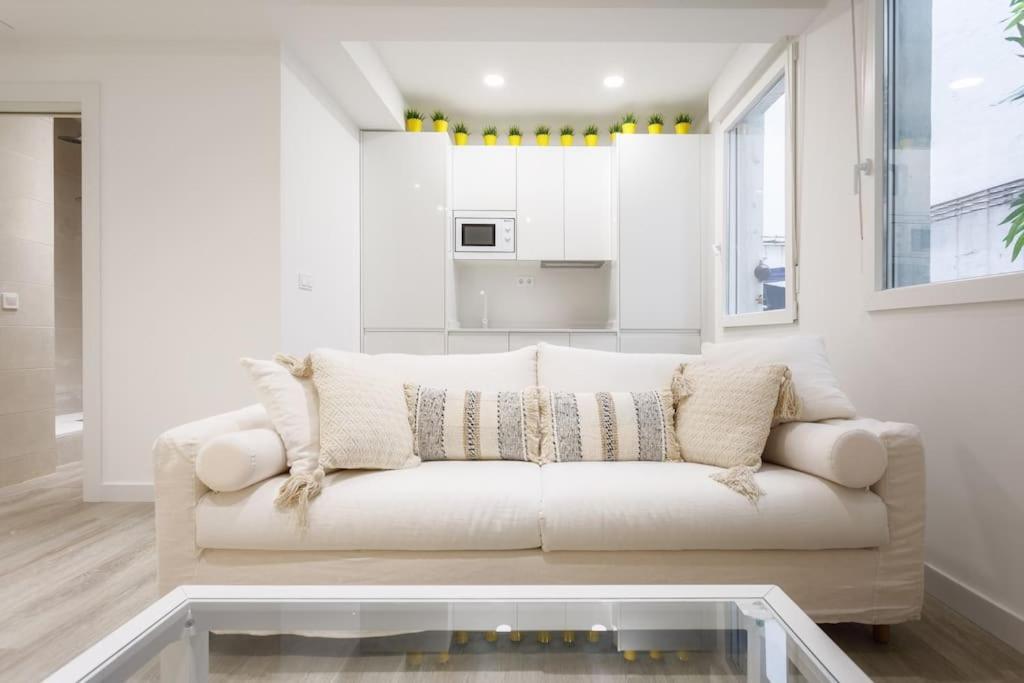 a white living room with a white couch and a kitchen at Heart of City Centre & Museum by Next Stop Bilbao in Bilbao