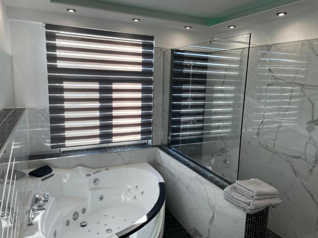 a white bathroom with a tub and a shower at Hotel Anker in Großenlinden