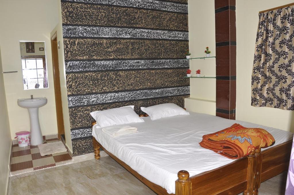 a small bed in a room with a wall at Sai Ram Home Stay in Hampi
