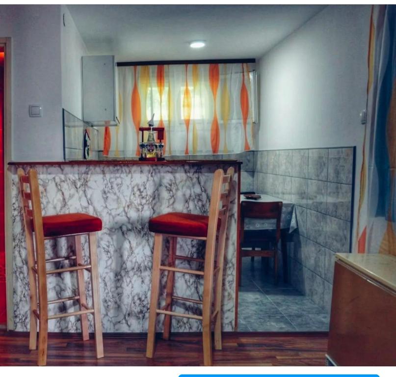 un bar con 2 sillas y un mostrador con mesa en Apartman Jovanovic-Rudnik en Rudnik