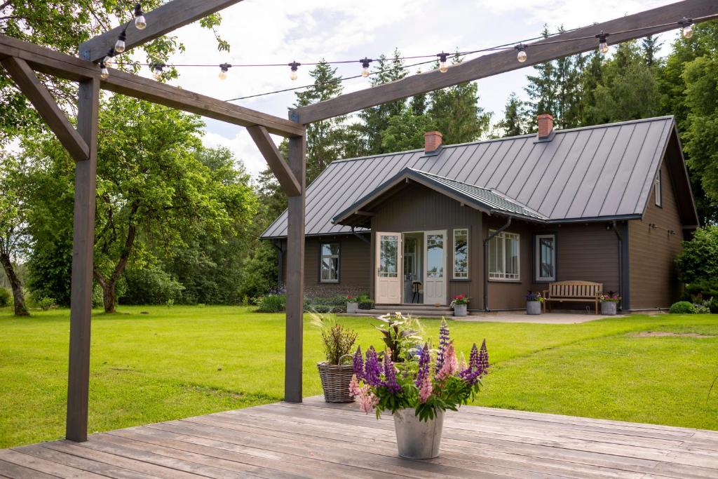 ein Haus mit einer Veranda und einer Holzterrasse in der Unterkunft Newly renovated Latvian farm house in Kraujas