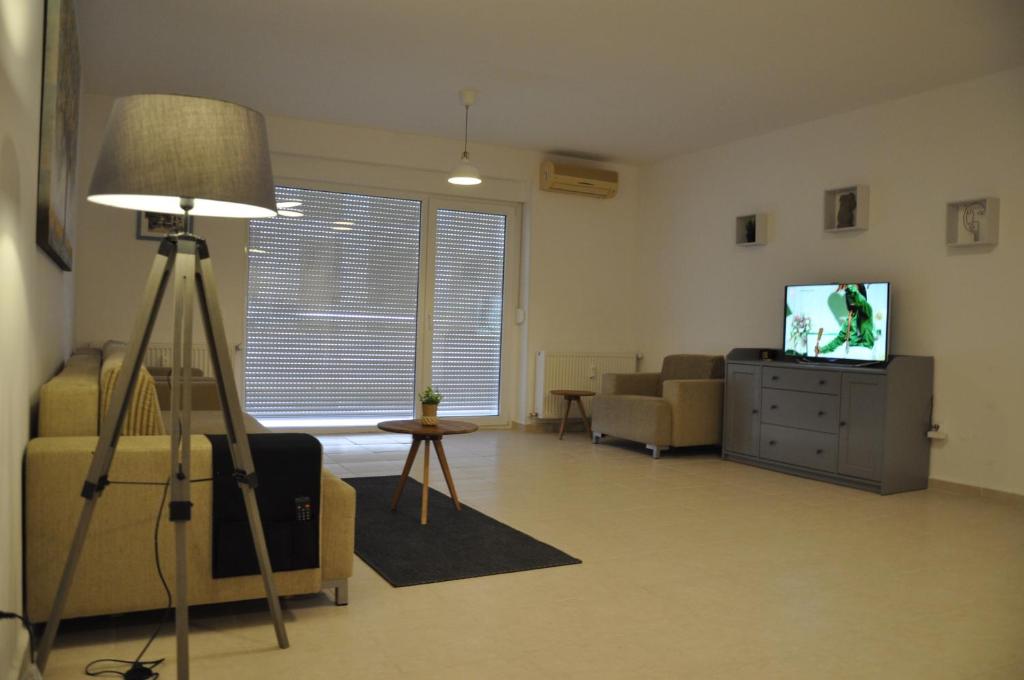 a living room with a lamp and a television at Coral ONIX in Neptun