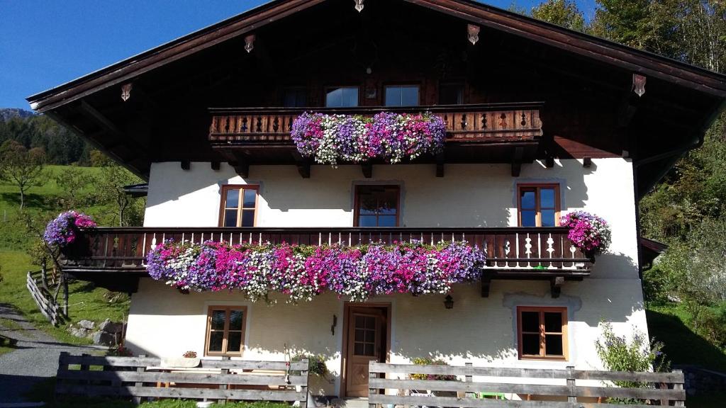 a white house with flowers on the balcony at Ferienzimmer Brennerbauer in Lofer