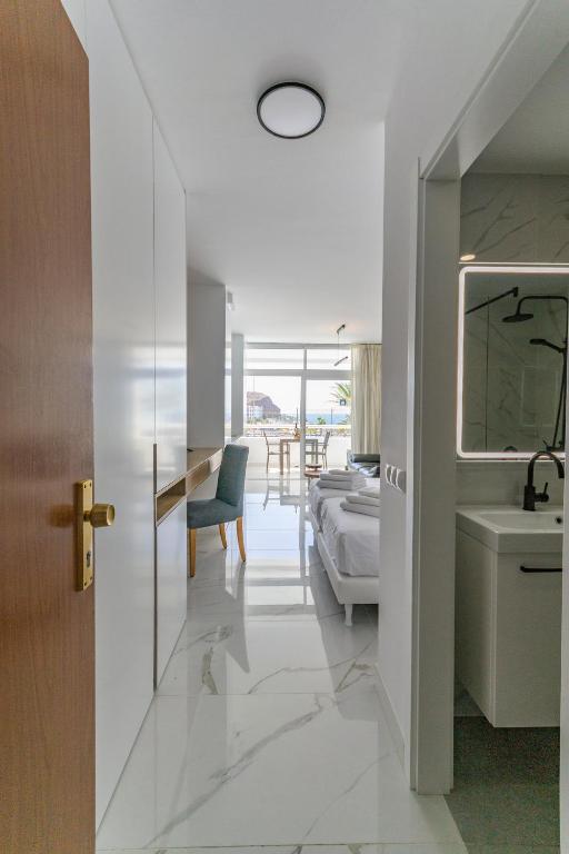 a bathroom with a sink and a bed in a room at Apartamento Tobago - Puerto Rico in Puerto Rico de Gran Canaria