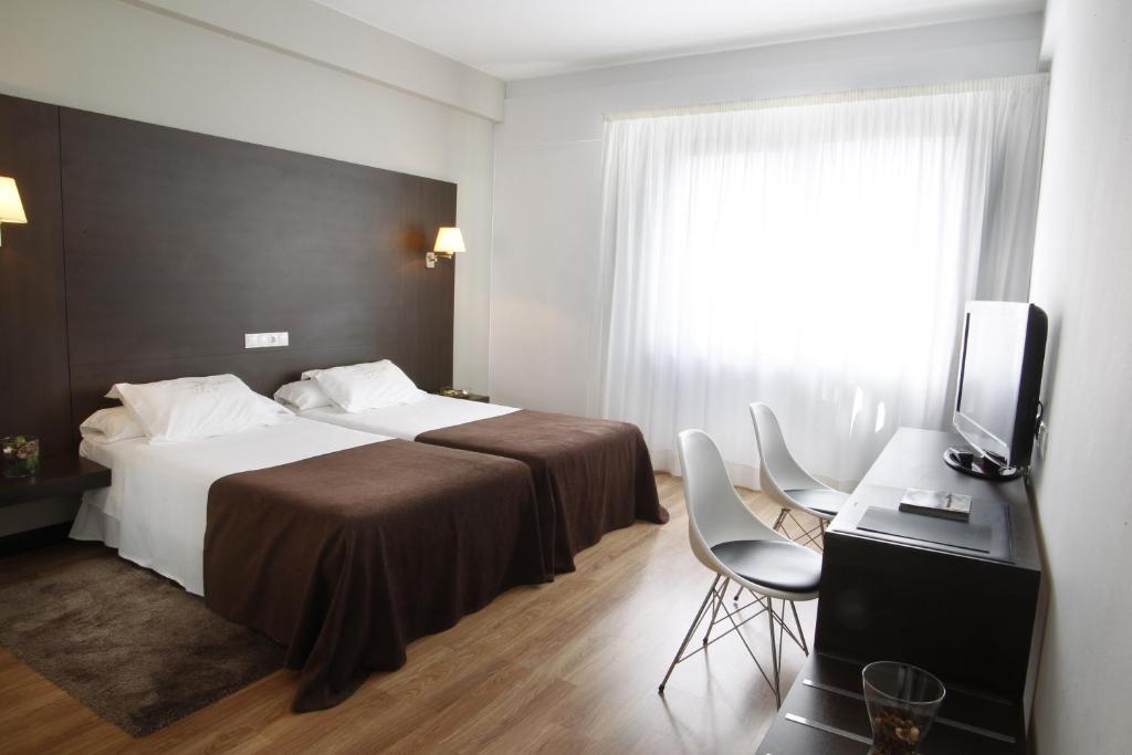 a hotel room with a bed and a television at Hotel Mendez Nuñez in Lugo