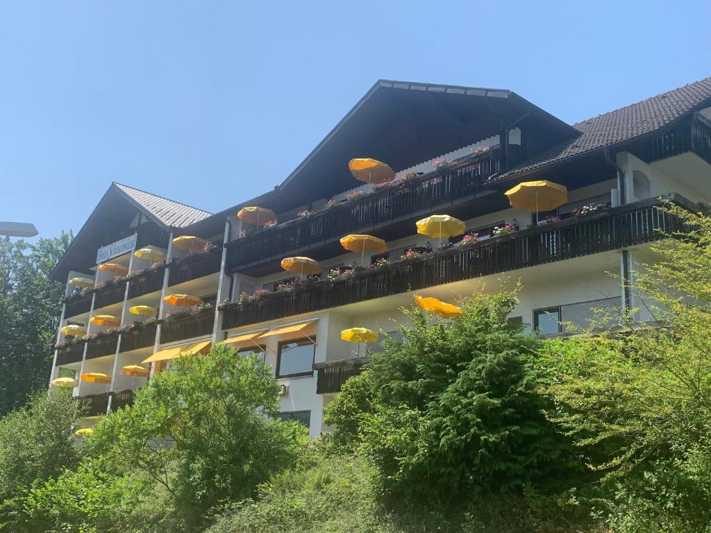 ein Apartmenthaus mit Sonnenschirmen auf dem Balkon in der Unterkunft Hotel Schauinsland in Bad Peterstal-Griesbach