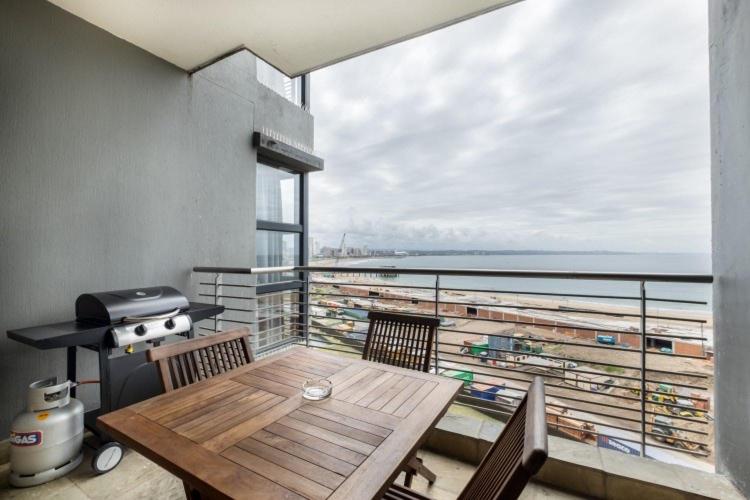 een balkon met een tafel en uitzicht op de oceaan bij Durban Point Waterfront, 805 Quayside 40 Canalquay Rd in Durban