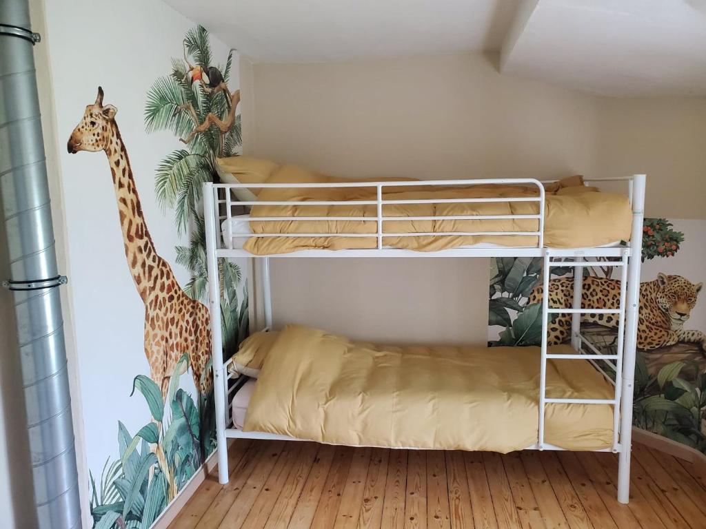 ein Schlafzimmer mit einem Etagenbett und einem Giraffenbild in der Unterkunft Gîte de la Porte des Lacs in Berzée