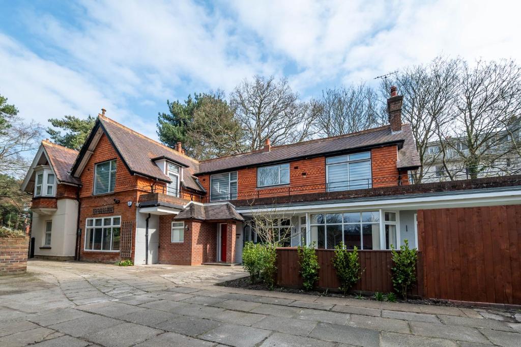 a brick house with a fence in front of it at The Manor - Large Luxury home in Bournemouth - Sleeps 12+ in Bournemouth