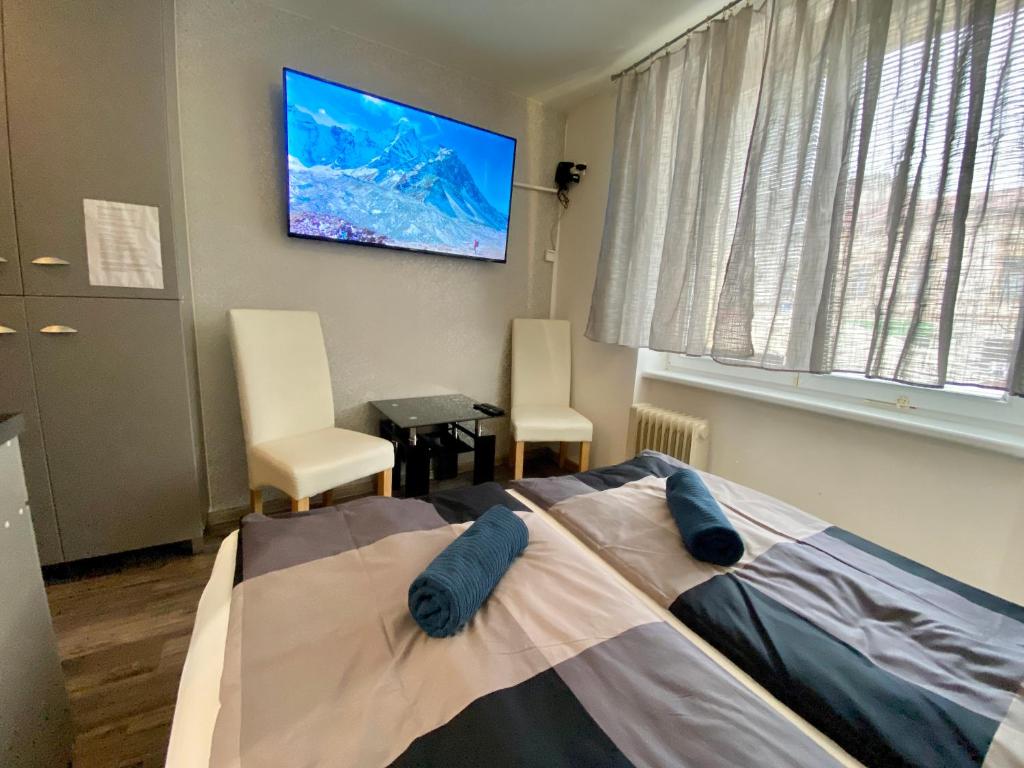 een slaapkamer met een bed en een tv aan de muur bij 24 hour-Self Check-in Apartment Námestie Svätého Egídia in Poprad