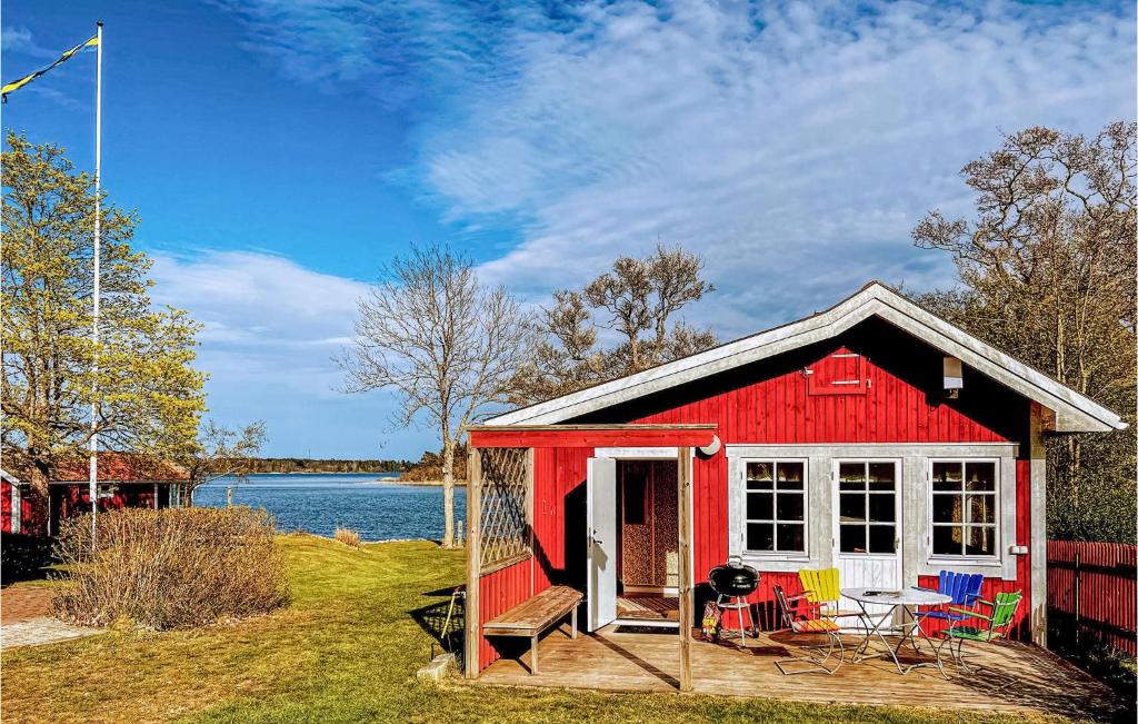 uma casa vermelha e branca com cadeiras e uma mesa em Lovely Home In Grdd With Sauna em Gräddö