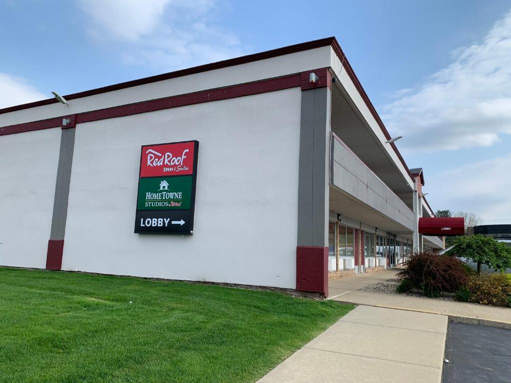 a store with a sign on the side of a building at HomeTowne Studios by Red Roof Battle Creek in Battle Creek