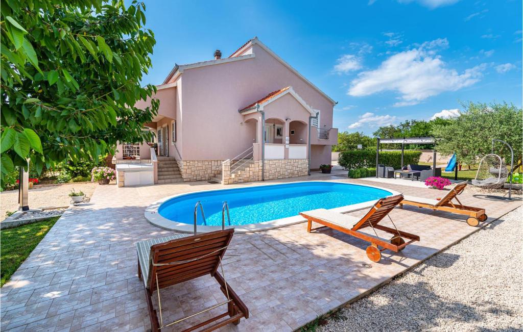 uma piscina com duas cadeiras e uma casa em 3 Bedroom Gorgeous Home In Zadar em Murvica