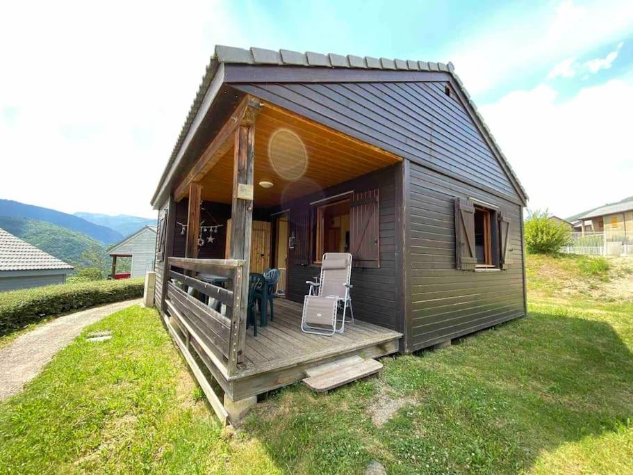 a small shed with a porch and two chairs at Chalet cosy Ignaux - Ax les thermes in Ignaux