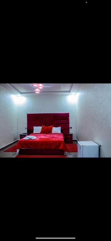 a bedroom with a red bed with a red blanket at HOTEL BORJ EL ARAB in Khouribga