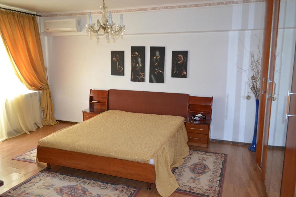 ein Schlafzimmer mit einem Bett und einige Bilder an der Wand in der Unterkunft Unirii 64 in Bukarest