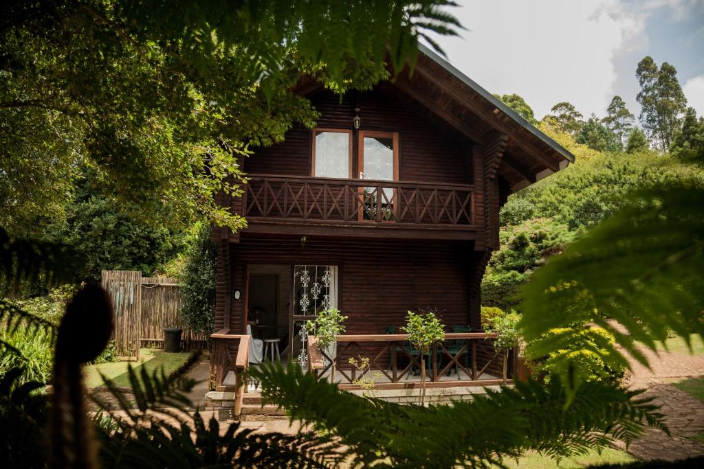 ein Holzhaus mit einer Veranda und einem Balkon in der Unterkunft Viewpoint - Cabin 3 in Haenertsburg