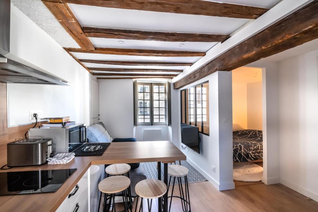 Cette chambre dispose d'une cuisine avec une table et des tabourets. dans l'établissement L’Arbre aux Hérons, à Nantes