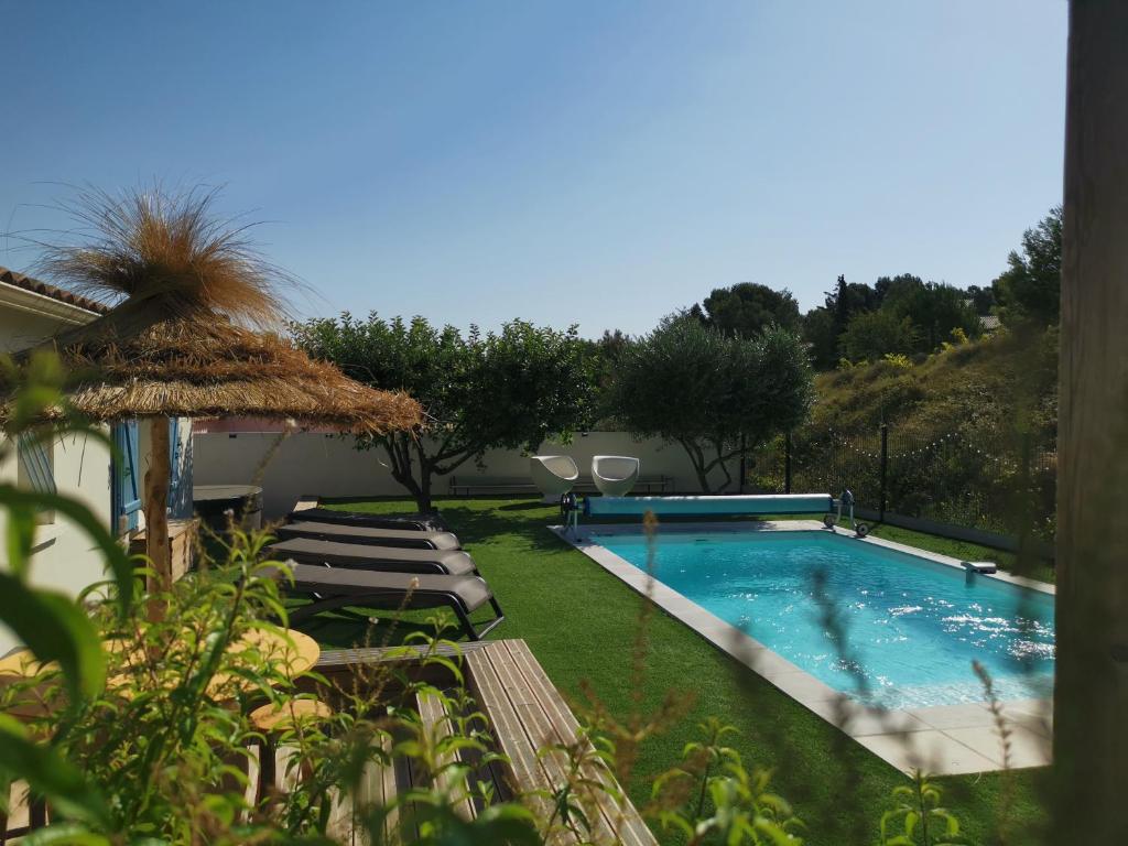 una piscina con sedie a sdraio accanto a una casa di Maison L'Inattendu avec spa & piscine privatifs a Moussan
