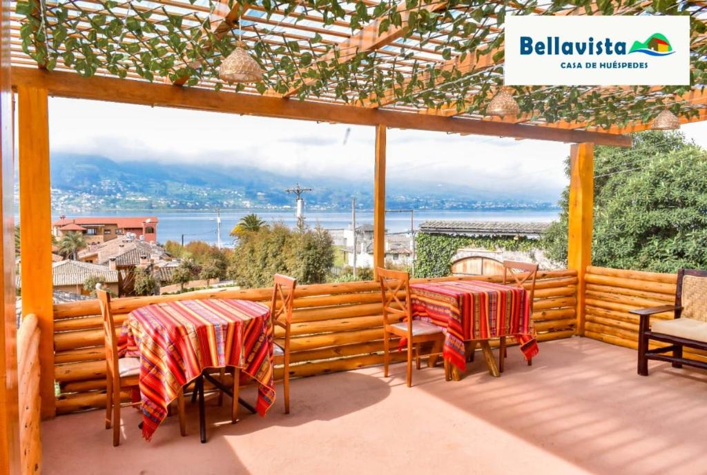 - deux tables et chaises sur une terrasse avec vue sur l'eau dans l'établissement Bellavista Casa de Huéspedes, à San Pablo