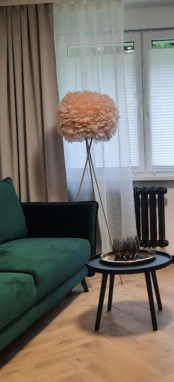 a living room with a green couch and a table at GOLD&BLACK OŚWIĘCIM CENTRUM in Oświęcim
