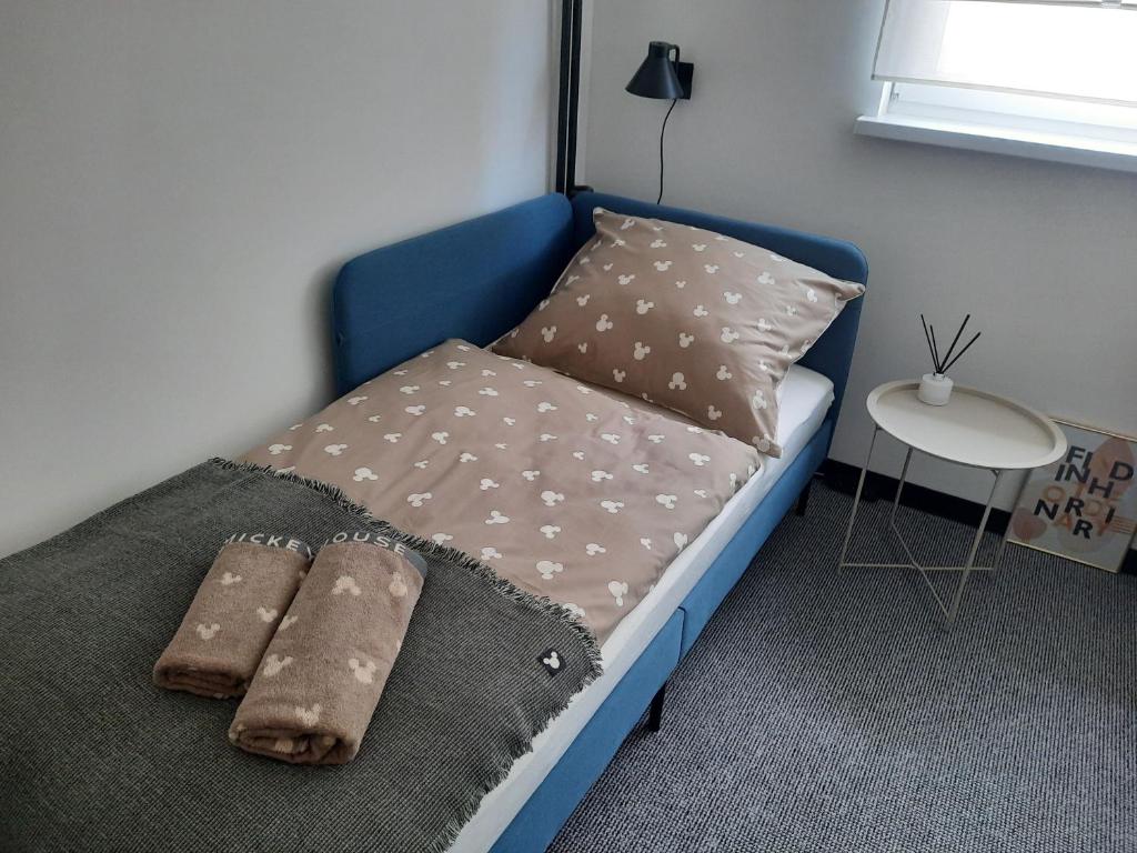 niebieskie łóżko z poduszkami i kocem w obiekcie GOLD&BLACK OŚWIĘCIM CENTRUM w Oświęcimiu