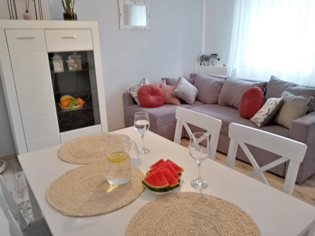 salon ze stołem i 2 kieliszkami wina w obiekcie Apartament Ostoja w mieście Mrągowo