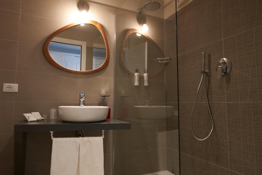 a bathroom with a sink and a shower with a mirror at Hotel B&B il Mosaico in Sirmione
