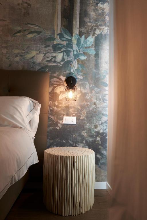 a bedroom with a bed and a wall with a painting at Hotel B&B il Mosaico in Sirmione
