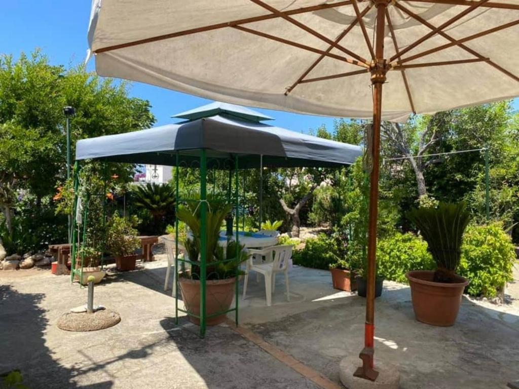 a large umbrella sitting next to a table with plants at Case Vacanze Tropea La Pinnata in Tropea