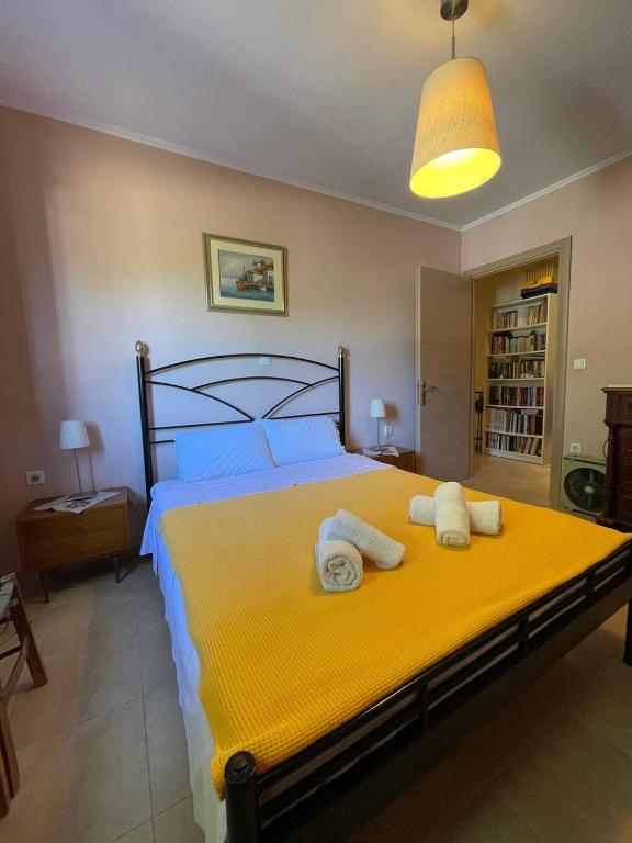 a bedroom with a large yellow bed with towels on it at Evak Chalet in Paleo Tsifliki