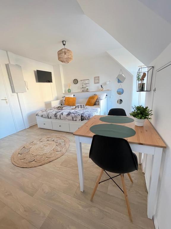 een slaapkamer met een bed en een tafel en stoelen bij Hyper centre ideal aeroport Beauvais in Beauvais