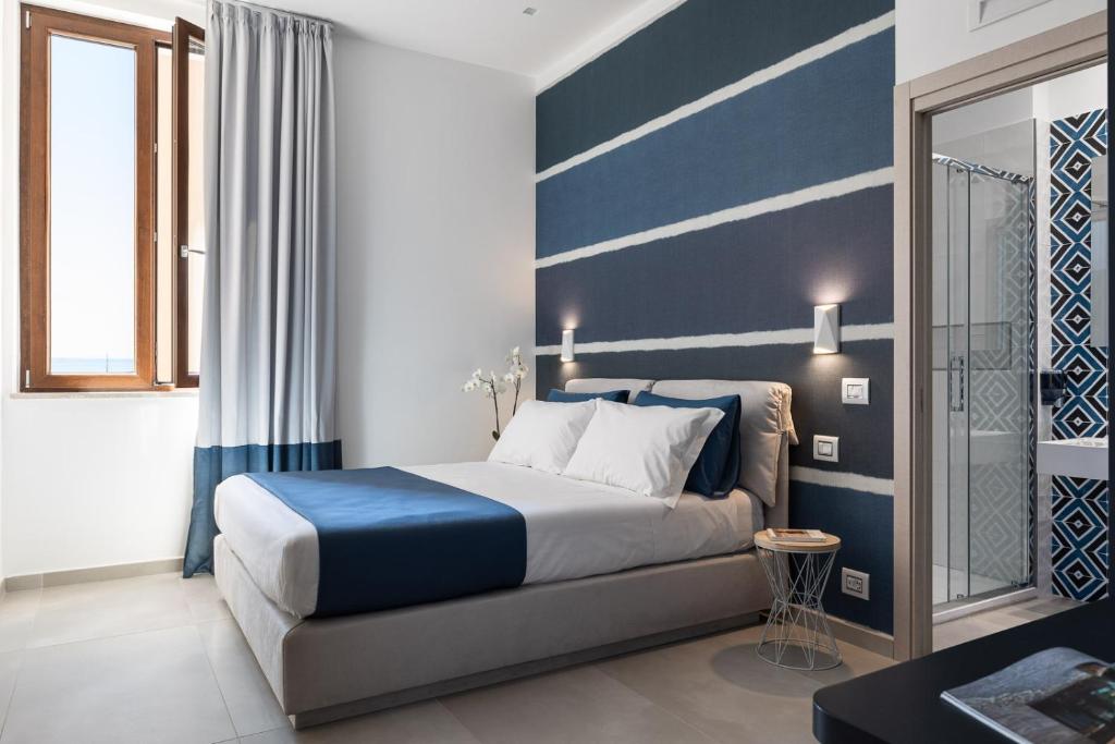una camera con un letto con una parete a righe blu e bianche di Torre Mola Suite a Formia