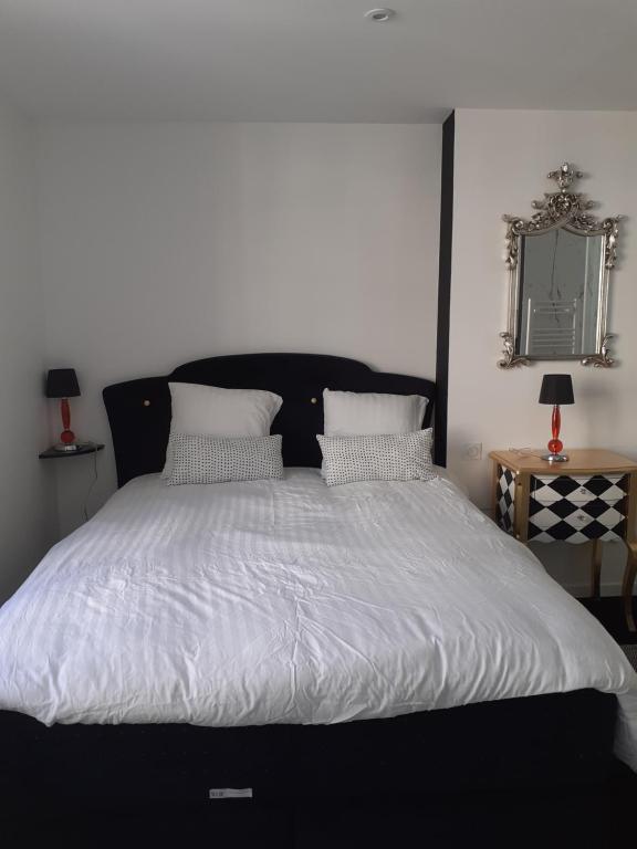 a bedroom with a large bed with white sheets and pillows at Appartement OH! Duc de Sully in Sully-sur-Loire